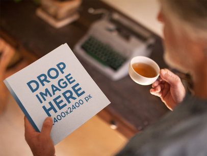 Elder Man Holding a Square Book While Drinking a Tea Template