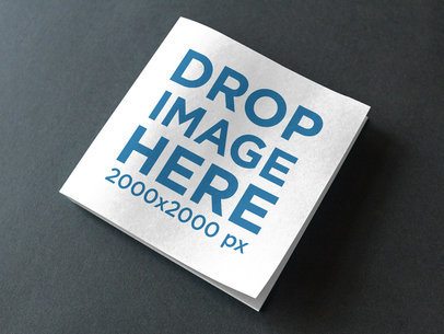 Angled Template of a Square Booklet Lying Closed on a Dark Gray Surface a14582
