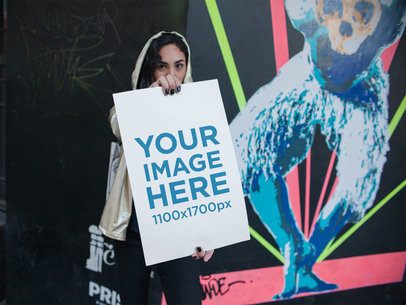 Trendy Woman Holding a Poster While Wearing a Shiny Golden Hoodie Mockup