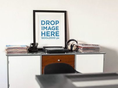 Framed Art Print Template on a White Wall Nearby a Turntable and Vinyls