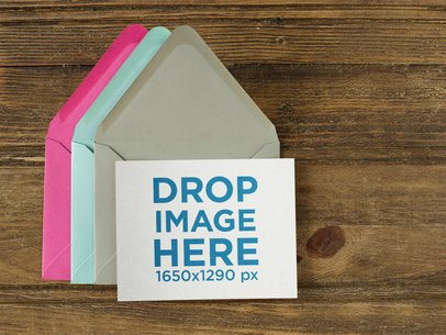 Invitation Template Over Three Colorful Envelopes on a Wooden Template