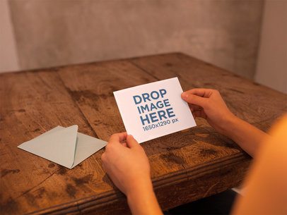 Woman Holding an Invitation Template on a Wooden Table