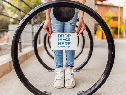 Woman Holding a Half Letter Flyer Mockup While at the Bike Station