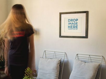 Blonde Woman Moving Her Hair While a Framed Art Print Template is on a White Wall