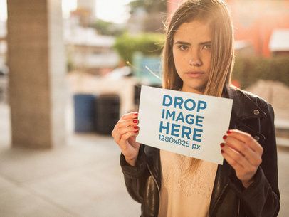 Serious Blonde Woman Holding a Horizontal Flyer Mockup With a Sunset in the Back