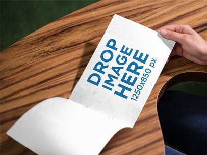 Woman Reading a Small Catalog Template While on a Wood Surface