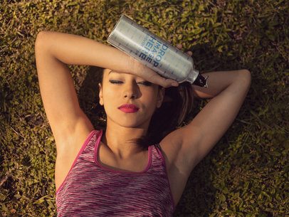 Hispanic Young Woman Relaxing After Exercise While Holding an Aluminum Water Bottle in her Hand