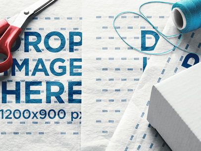 Folded Wrapping Paper Template Lying with Scissors and Thread Above it a14959