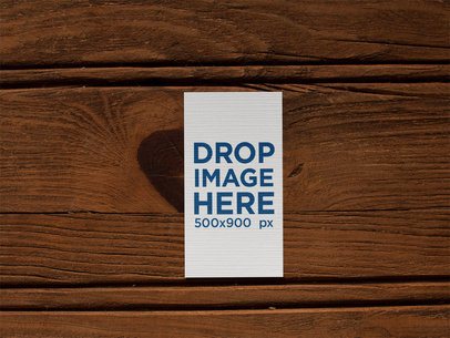 Vertical Business Card Mockup Lying on a Wooden Surface