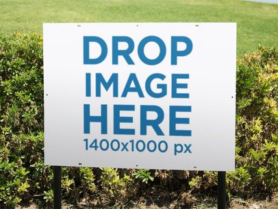 Real Estate Lawn Sign Mockup Outdoors Near the Grass and a Bush