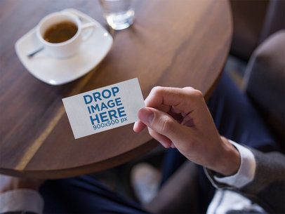 Mockup of a Business Card Being Held While Inside a Cafe